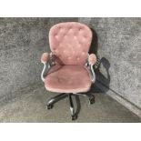 An office swivel chair upholstered in pink suede