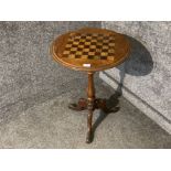 A Victorian inlaid walnut games table raised on tripod feet