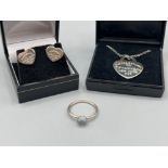 Silver blue stone ring accompanied with white metal heart pendant and earrings in the style of