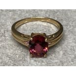 A 9ct yellow gold and purple three stone ring size M 1/2 2.5g gross
