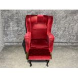 Vintage armchair upholstered in red fabric with footstool