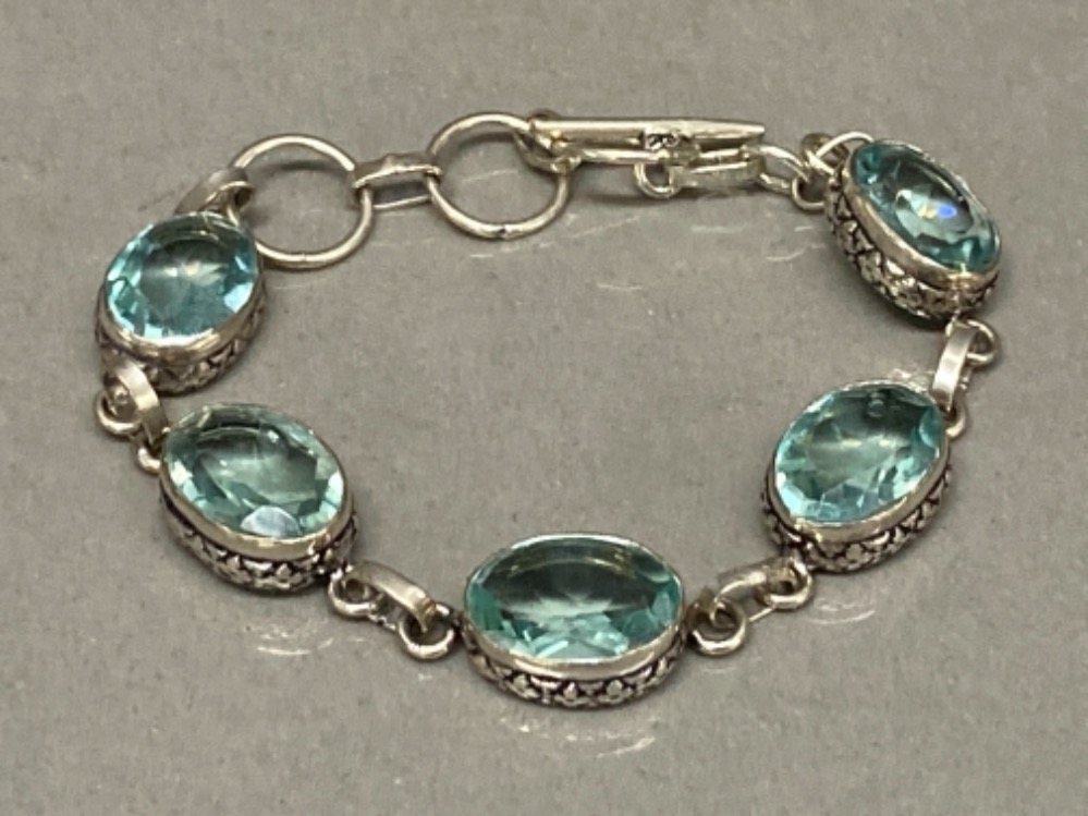 A silver and five blue stone ring bracelet