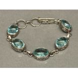 A silver and five blue stone ring bracelet