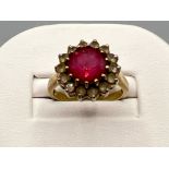 Ladies 9ct gold cluster ring. Featuring a red round stone surrounded by 14 white stones. 4.7g size