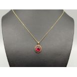 Ladies 9ct gold stone set pendant and chain. Comprising of a red stone set in fancy setting. 2.6g