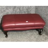 A red leatherette pouffe