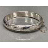 A sterling silver bangle with safety chain 10.8g gross