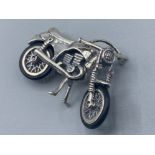 An unusual silver articulated motor cycle with rubber tyres