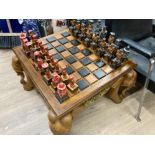 A carved wooden and hand painted square shaped games table with pieces