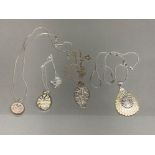 Four silver pendants on silver chains of different designs 32g