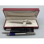 A Sheaffer ball point pen, boxed and three Parker pens