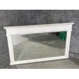 An antique white painted over mantle bevelled mirror