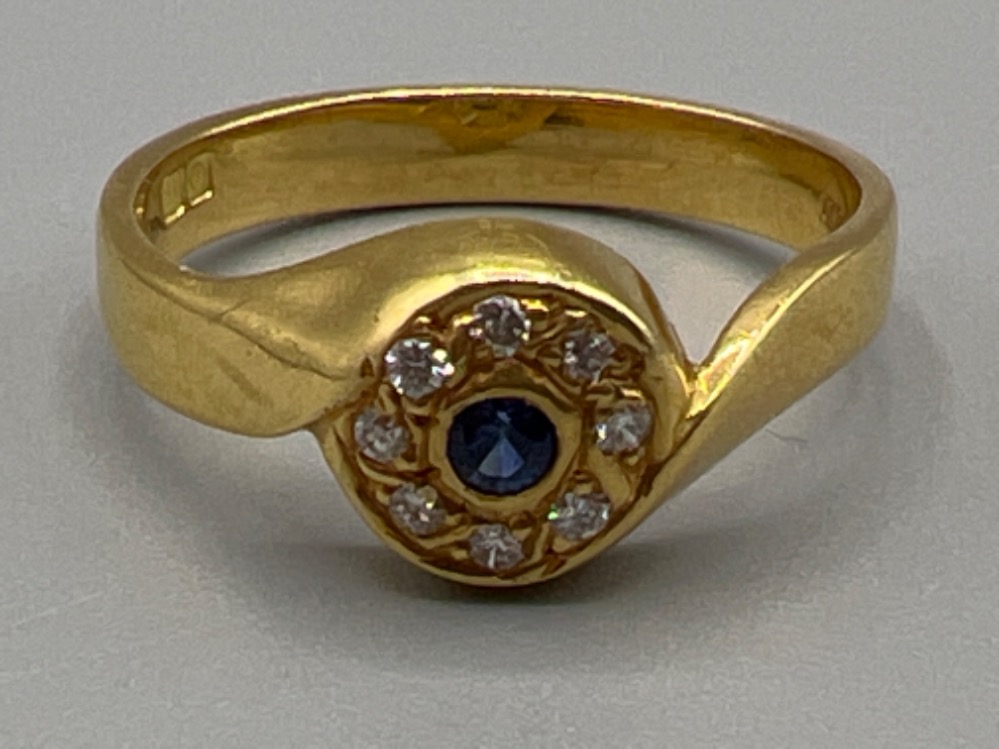 Ladies hallmarked 18ct gold sapphire and diamond ring. Comprising of a Round cut sapphire surrounded