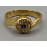 Ladies hallmarked 18ct gold sapphire and diamond ring. Comprising of a Round cut sapphire surrounded