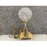 An antique metal table lamp with cut glass shade and gilt Hippocampi