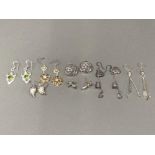 Seven pairs of silver earrings some with stones in