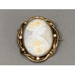 Victorian gilt metal cameo brooch with pearl decoration, with safety chain