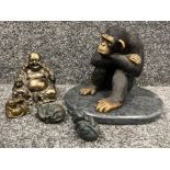 Large chimpanzee sitting on marble along with 2 Buddhas and mice