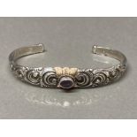 A silver and 22k gold plated bangle with purple stone to centre 22g gross