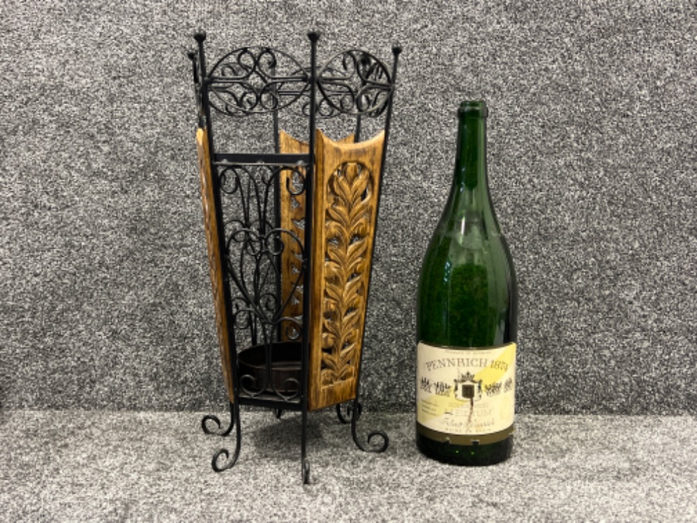 Decorative umbrella stand and large empty German champagne bottle.