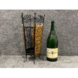 Decorative umbrella stand and large empty German champagne bottle.