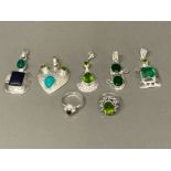 Five silver and green stone pendants and two silver rings