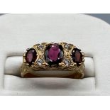 Ladies 9ct Yellow Gold 3 stone ring, comprising of 3 oval garnets set with 2 cubic Zirconias