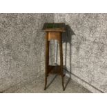 An Arts and Crafts oak plant stand with green tiled inset top