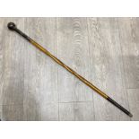 An early 20th century walking cane with dot prick decorated horn handle and white metal collar