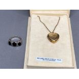 Silver and garnet three stone ring size M 4.2g gross, and a rolled gold heart shaped locket and