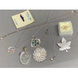 Box containing an assortment of silver & white metal pendants & brooches