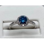 18ct white gold ring comprising of a 0.60ct blue diamond surrounded by a total of 0.30cts of