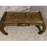 Heavily carved oriental style coffee table, with well detailed Asian scene protected by glass top,