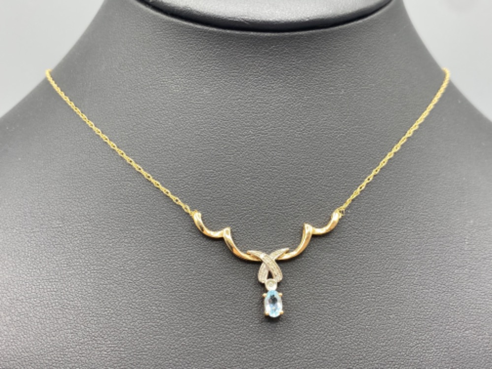9ct Gold nine diamond and oval aquamarine pendant and chain, 3g