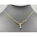 9ct Gold nine diamond and oval aquamarine pendant and chain, 3g