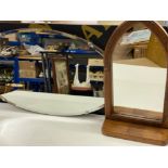 Vintage oval shaped frameless mirror together with a church style wooden framed mirror