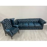 A large four seater blue leather chesterfield upholstered in blue leather, and a matching wingback
