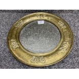 An arts & crafts circular bevelled glass mirror, brass framed with bark & Celtic knot design