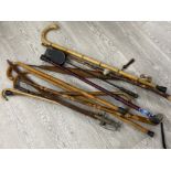 Bundle of walking sticks including carved Spanish child’s cane together with brass handled Indian