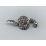 A silver snake brooch set with rubies and emerald eyes 6.63g gross
