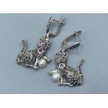 A pair of unusual silver drop earrings of cat form set with Marcasite’s & Ruby cabochons, 10g gross