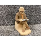 A ceramic old man reading a newspaper made by Deborah Warren 20cm high