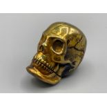 A brass cased skull vesta with strike plate