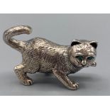 A well cast silver cat figure with emerald eyes