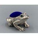 A silver frog pincushion with sapphire eyes, 15.7g