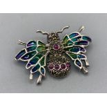 A silver and plique a jour bug brooch set with rubies, 4g