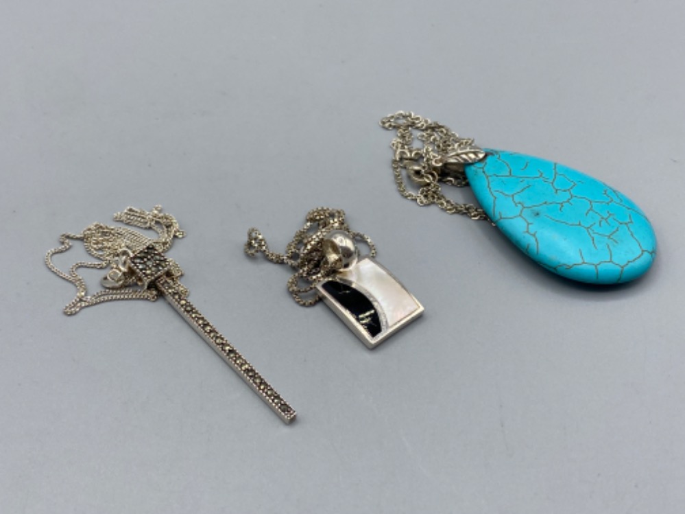 Three silver pendants on silver chains comprising turquoise, marcasite and enamel