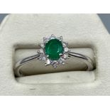 An 18ct white gold emerald and diamond cluster ring of 60 points, 3.2g size O