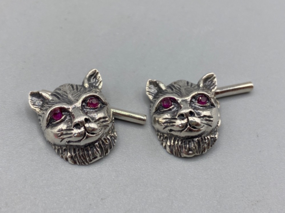 A pair of silver cat head cufflinks with ruby eyes, 5g