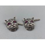 A pair of silver cat head cufflinks with ruby eyes, 5g